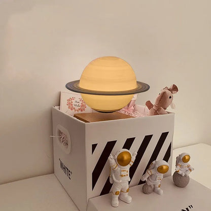 Maglev floating moon planet atmosphere night light with three astronaut figurines on a desk.