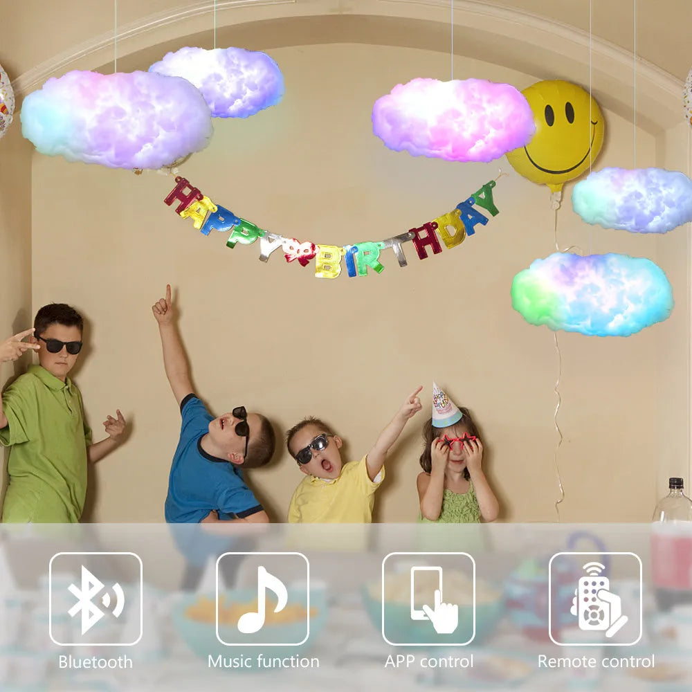 White fabric cloud shaped light hanging from ceiling with multi-coloured LED glow.