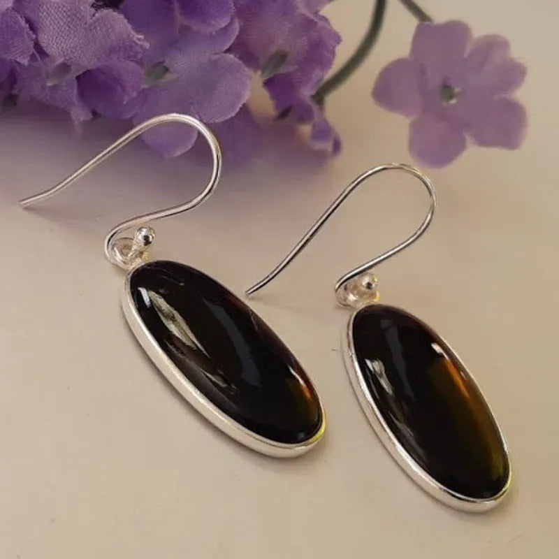 A pair of women's silver-plated alloy earrings with an oval black agate geometric pendant.