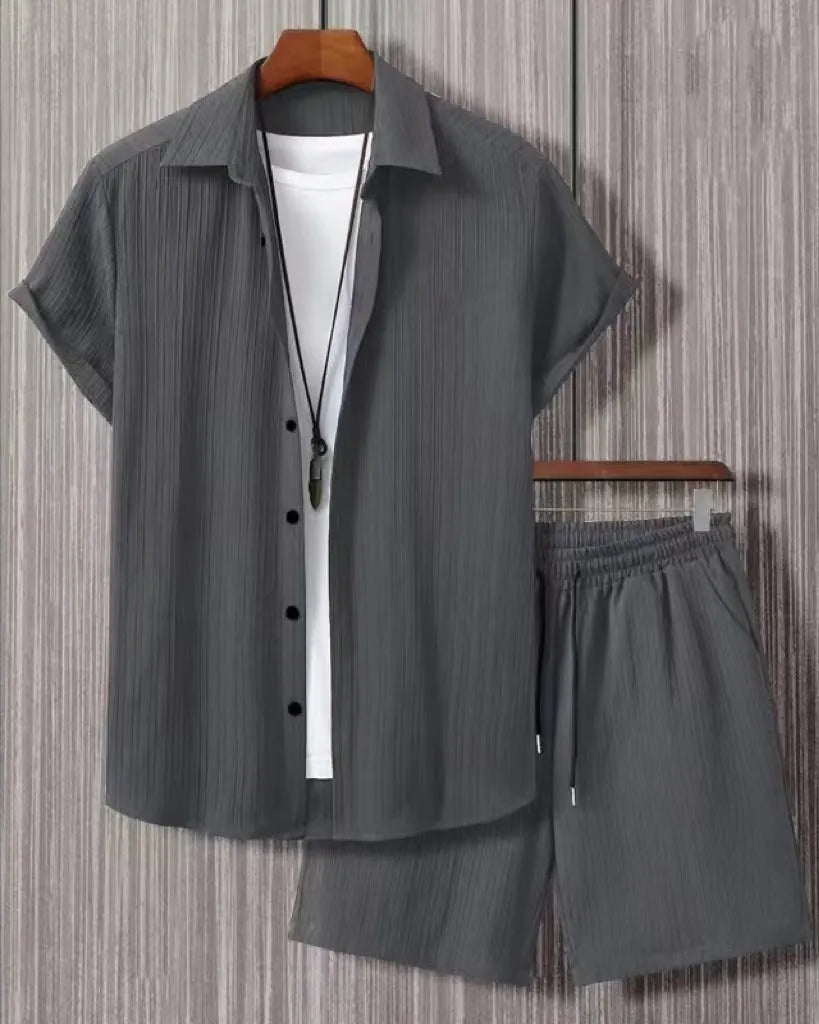 Man wearing a black and white jacquard short sleeve shirt and matching shorts suit set.