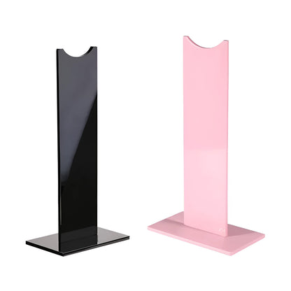 Pink and black detachable headset stand with non-slip silicone base on a desk.