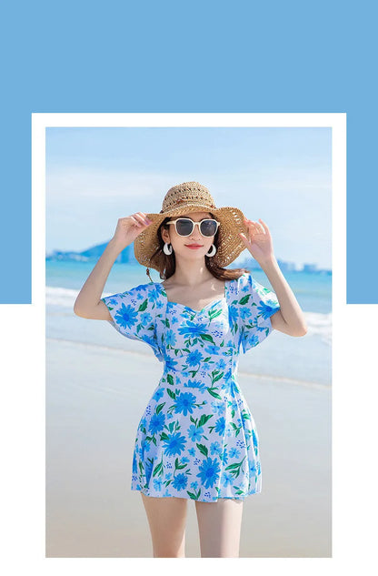 Blue floral print women's dress-style one-piece swimsuit on a hanger