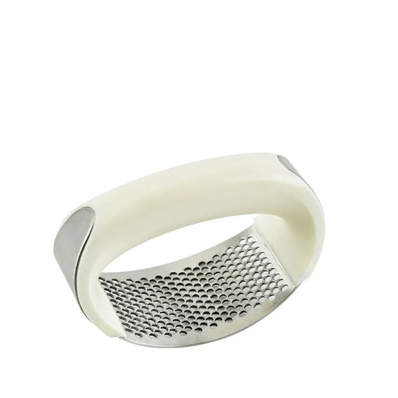 Stainless steel garlic press with ergonomic handle in assorted colours on a kitchen worktop.