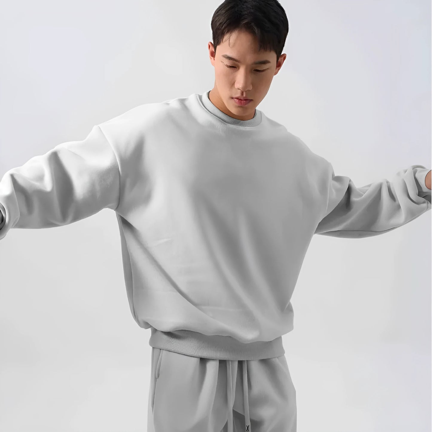 Man wearing a loose-fit army green polar fleece tracksuit with a crew neck jacket and matching padded trousers.