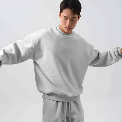 Man wearing a loose-fit army green polar fleece tracksuit with a crew neck jacket and matching padded trousers.