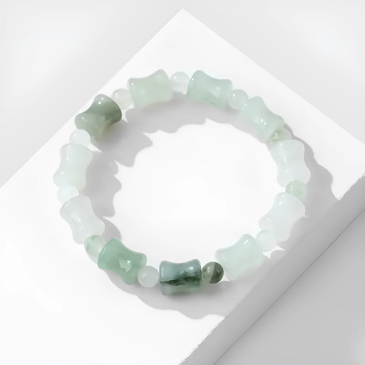 Simple Korean-style bracelet with natural chalcedony and coconut shell beads on an elastic string, showing the diamond-shaped safety lock.