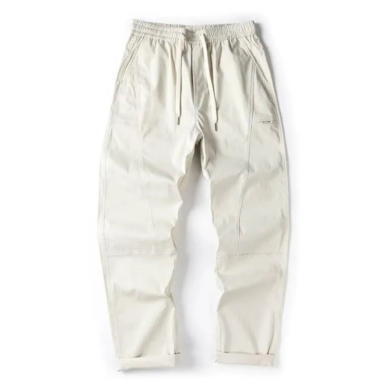 Beige cotton wide-leg trousers with an elasticated waistband laid flat.