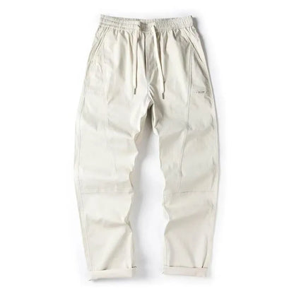 Beige cotton wide-leg trousers with an elasticated waistband laid flat.