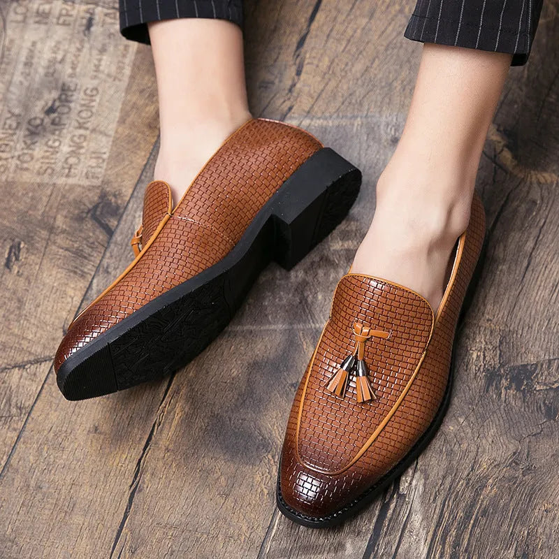 Men's black pointed toe slip on shoes with a tassel detail on the upper.
