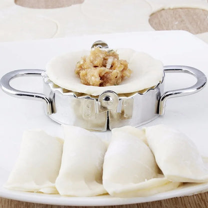 Stainless steel dumpling mould and rectangular dough cutter on a kitchen surface.