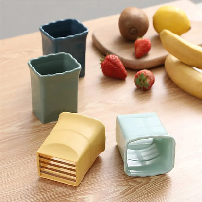 Green stainless steel cup-shaped kitchen slicer for cutting fruits and eggs on a countertop.