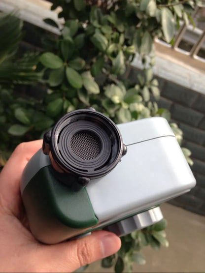 Green digital garden hose timer with large display shown connected to an outdoor tap.