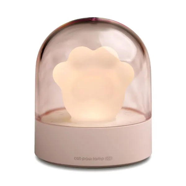 Grey cat paw shaped night light with USB port, glowing softly on a wooden surface.