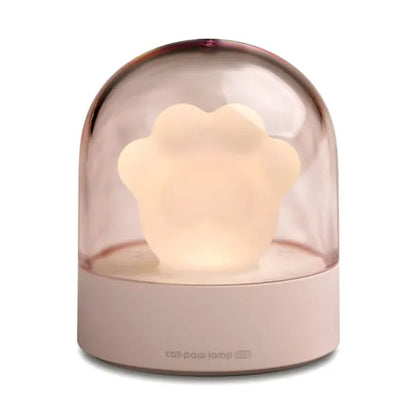 Grey cat paw shaped night light with USB port, glowing softly on a wooden surface.