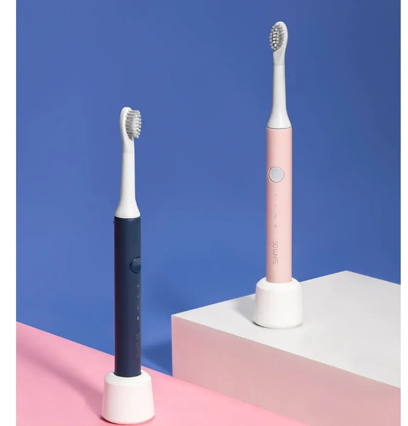 SOOCAS sonic electric toothbrush in blue or pink with round brush head on a bathroom counter.