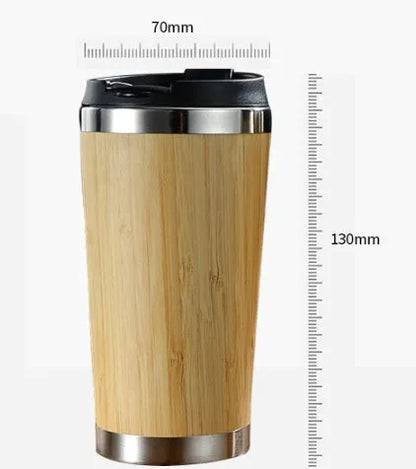 Natural bamboo fibre and stainless steel reusable travel coffee cup with black leak-proof lid on a table