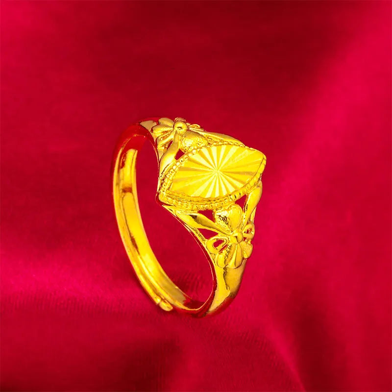 Geometric gold brass ring with open floral cut-out design and textured band, shown from the side.