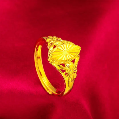 Geometric gold brass ring with open floral cut-out design and textured band, shown from the side.