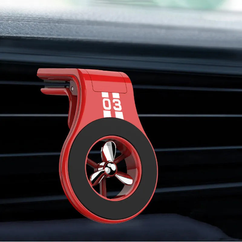 Black magnetic car phone holder attached to air vent with phone mounted and fragrance slice visible