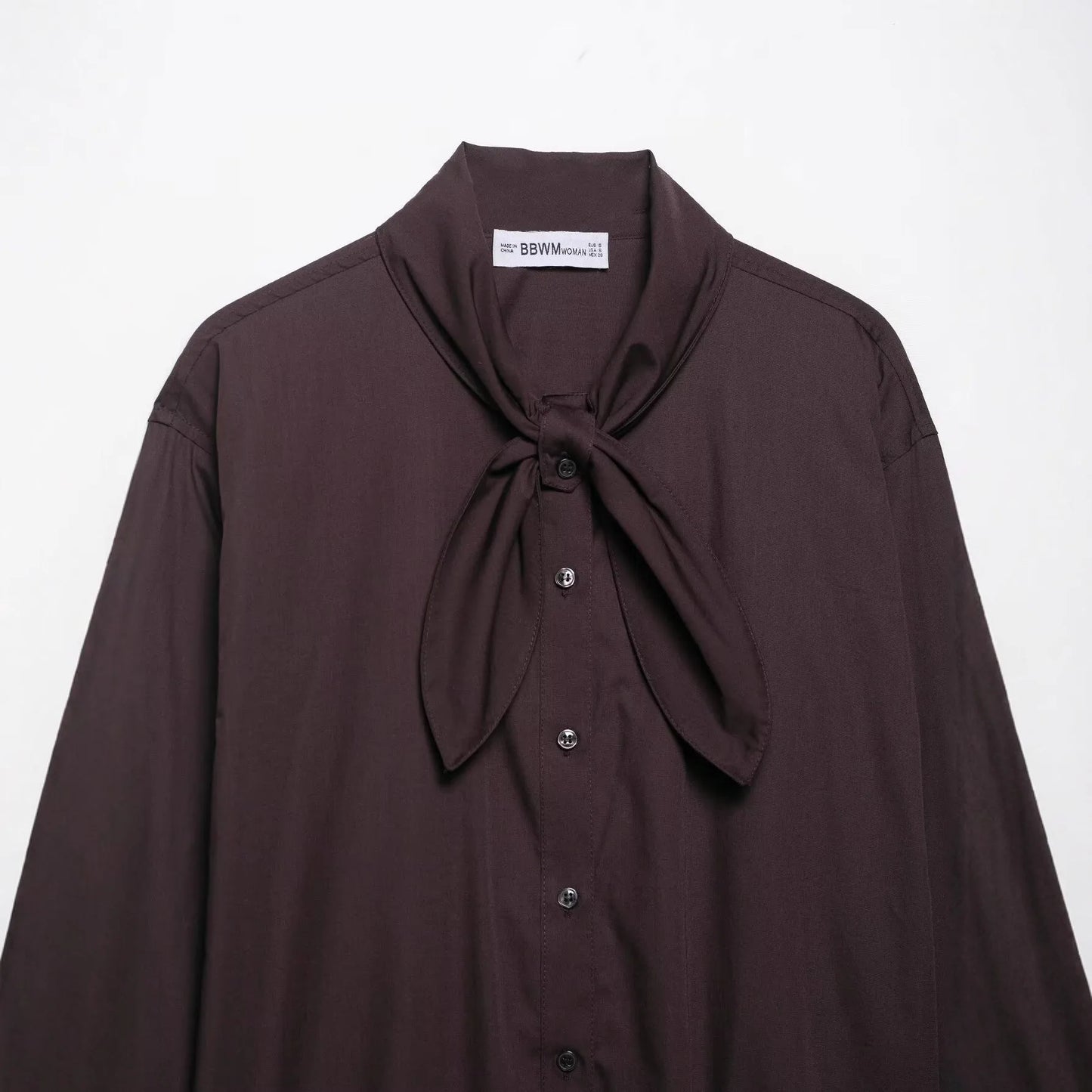 Brown women's loose-fit poplin shirt with long sleeves and an attached bow tie scarf.