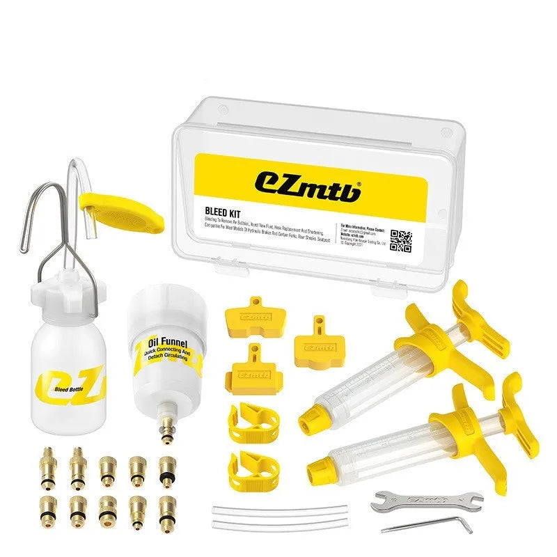 Bicycle hydraulic disc brake oil bleed kit tools with syringes, adapters, and wrenches on a workbench