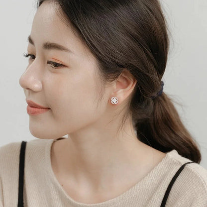 Elegant sterling silver stud earrings with delicate floral accents, suitable for both men and women