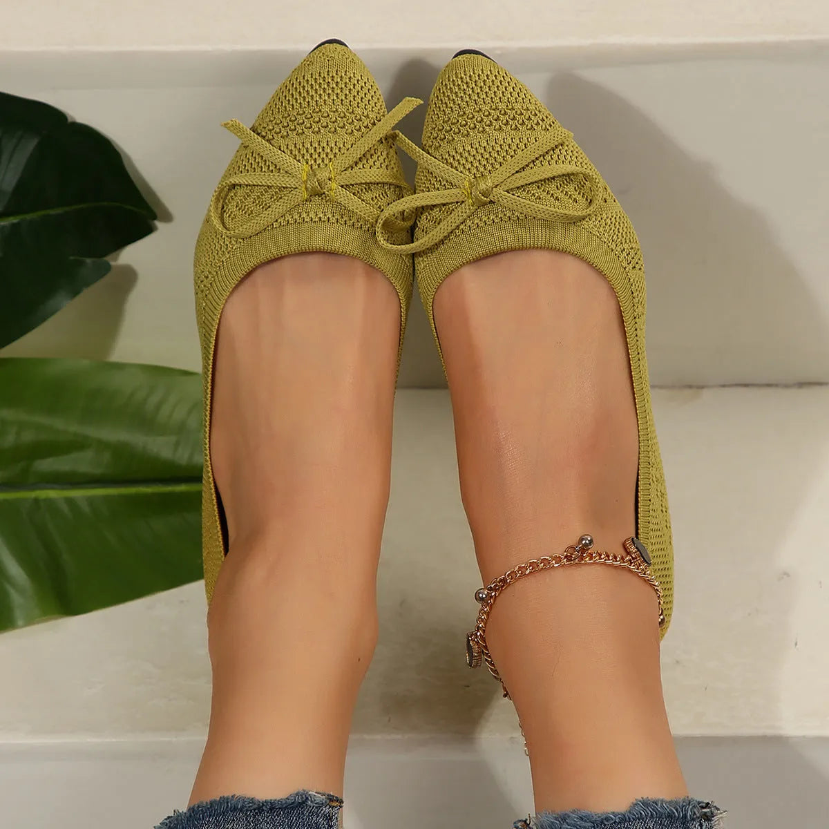 Women's blue knitted loafer flat shoes with a pointed toe and decorative bow detail on the front.