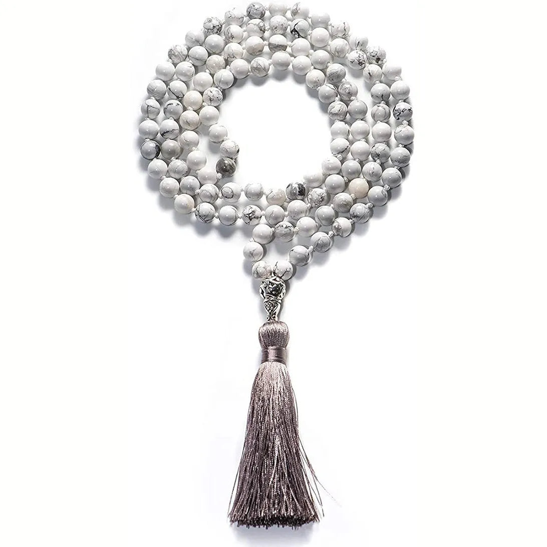Long multi-coloured agate and stone tassel necklace with geometric beads on a white background.