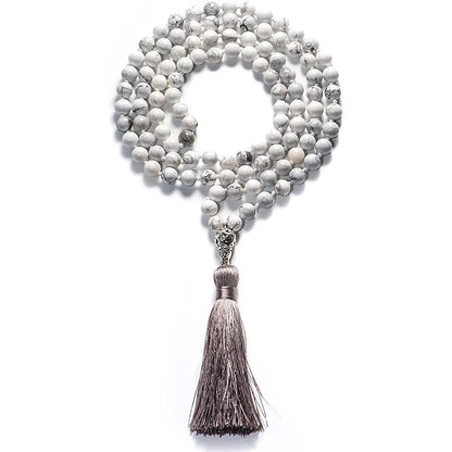 Long multi-coloured agate and stone tassel necklace with geometric beads on a white background.