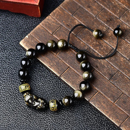 Handmade golden obsidian Pi Xiu bracelet with Chinese zodiac design on wrist.