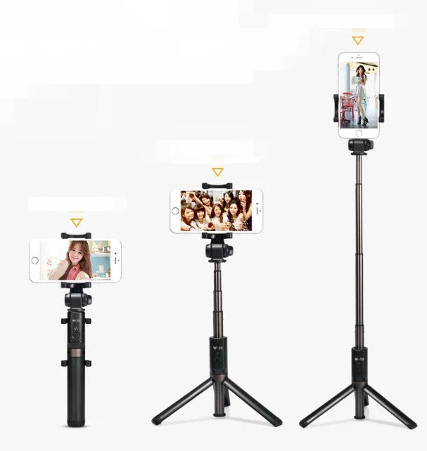 Aluminium tripod selfie stick with extended phone clip and Bluetooth remote on a table