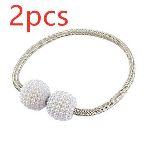 Magnetic curtain tiebacks with white pearl beads and fabric loops holding gathered curtain