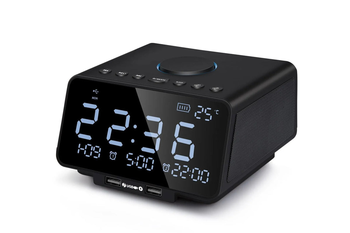 Black and white wireless alarm clock Bluetooth speaker with remote control on a table.