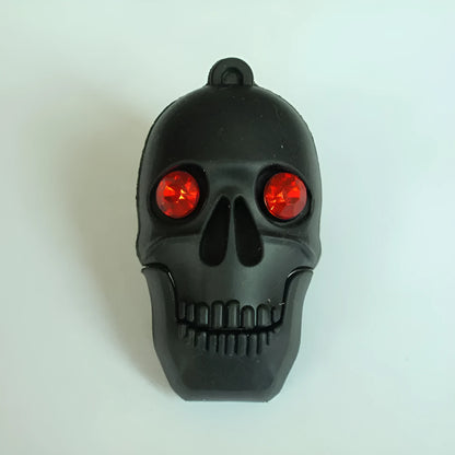 Skull-shaped black USB flash drive on a small metal keychain against a dark background.