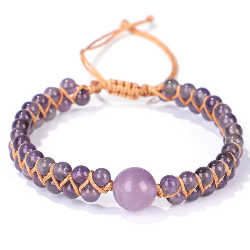 Close-up of a hand-woven geometric bracelet with a blue Tigereye stone on a wrist.