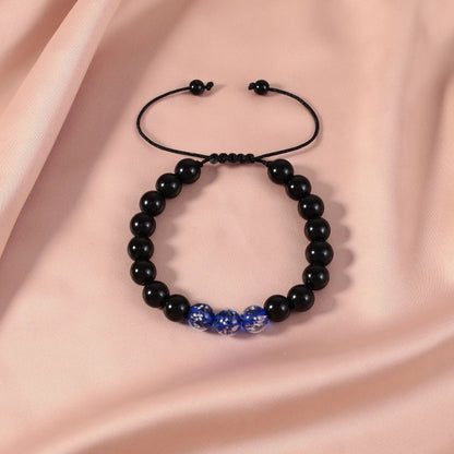 Adjustable luminous beaded bracelet with geometric glass beads on a stretchy elastic band in sapphire blue