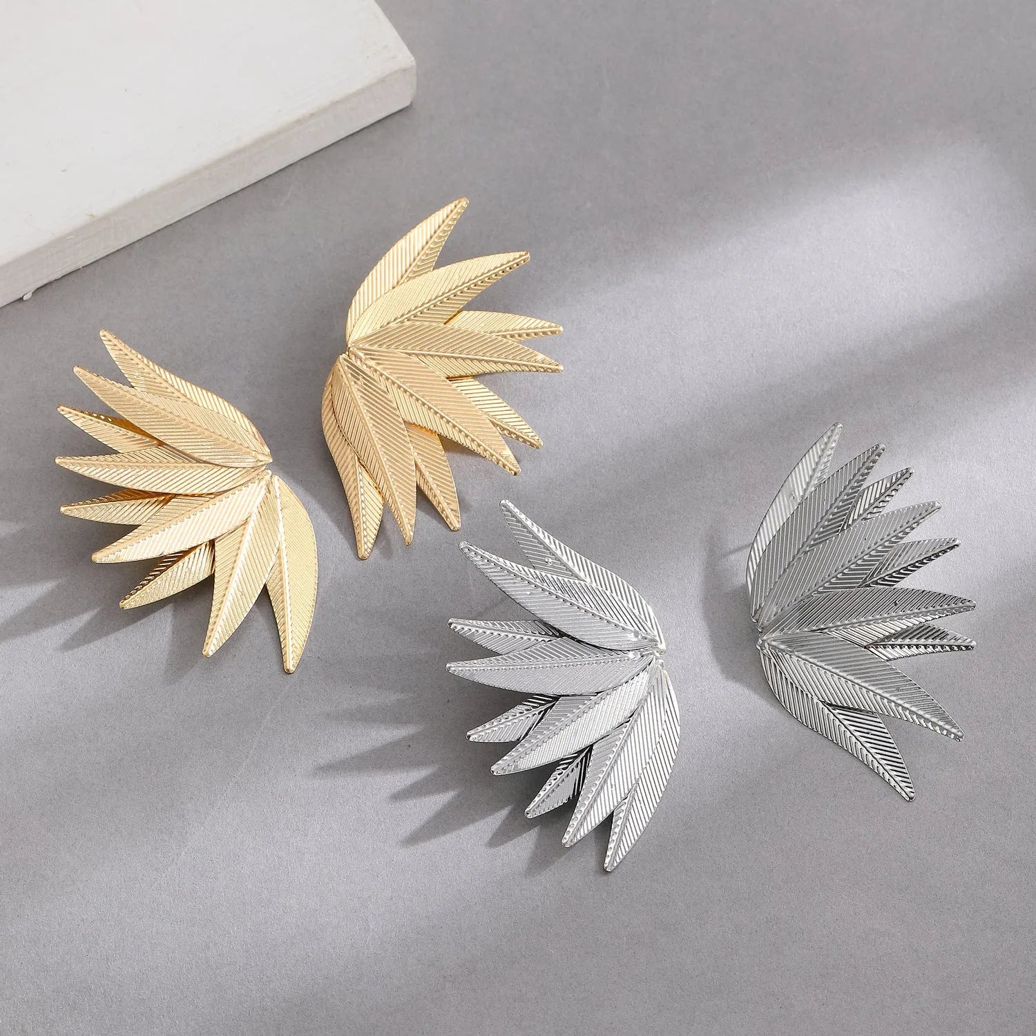 Gold and white alloy leaf-shaped patch earrings with botanical design