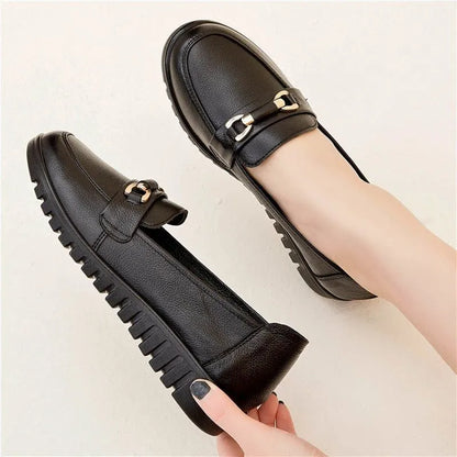 Black casual pumps with round toe, low flat heel, soft bottom, and a subtle metal detail on the upper.