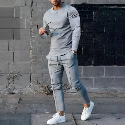 Men's solid colour two-piece lounge suit with long sleeve T-shirt and trousers in light grey.