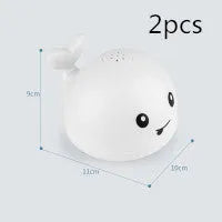 Grey or white electric whale bath toy spraying water with LED lights on a base.