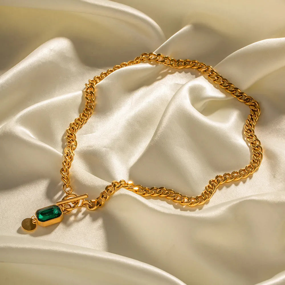 Gold geometric round pendant on a titanium steel Cuban link necklace, 50cm long.