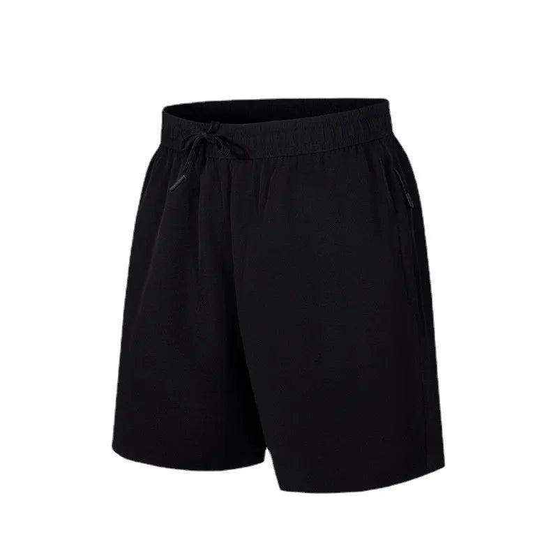 Man wearing black loose-fit quick-dry polyester sports shorts on a summer day.