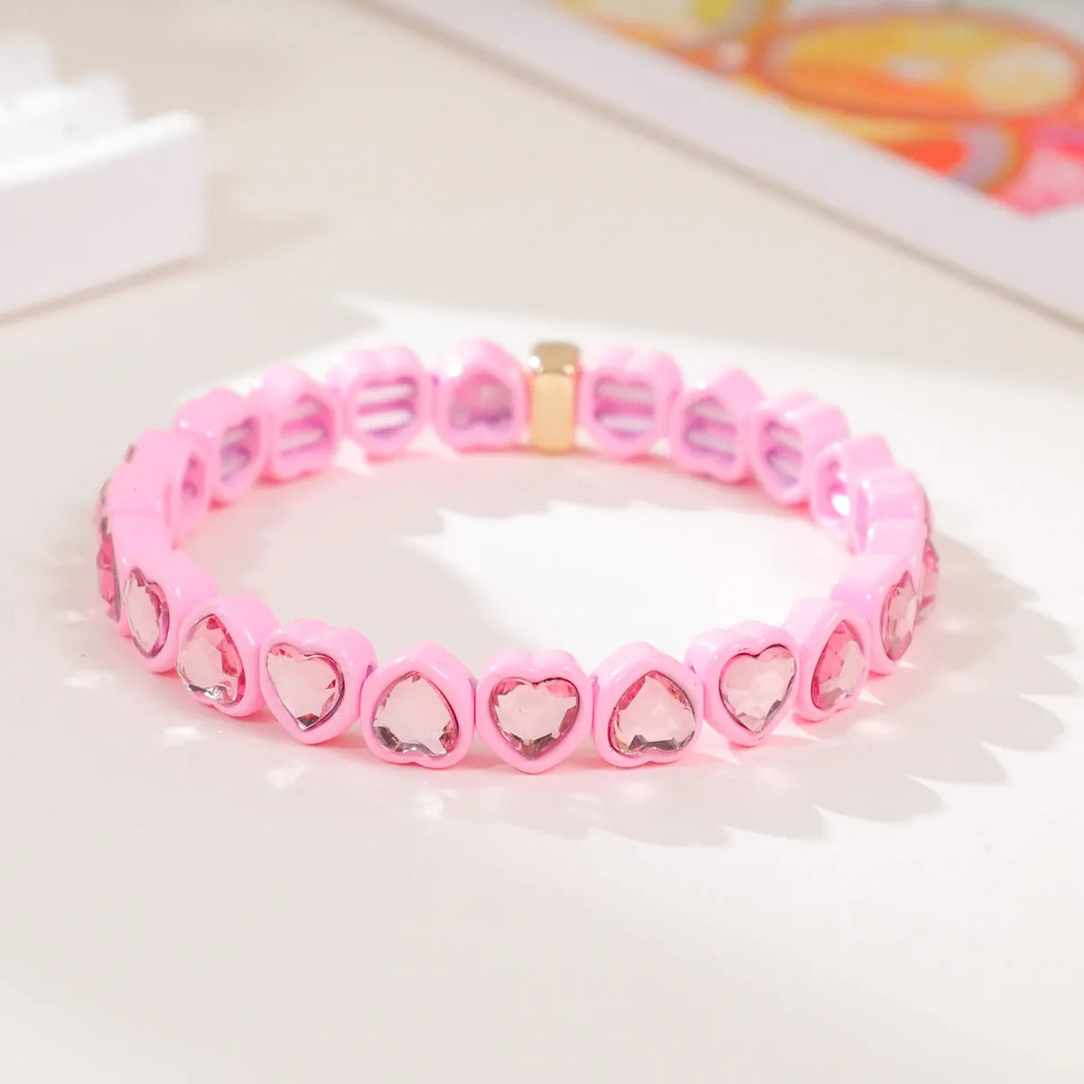 Colourful enamel heart shape on a silver-toned alloy stretch bracelet.