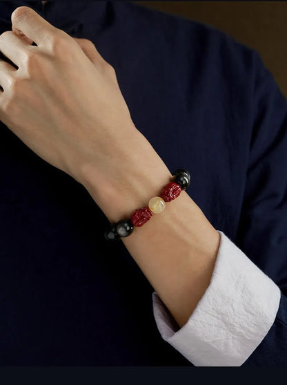Hand-carved cinnabar bead bracelet with animal zodiac designs in gold or silver stone