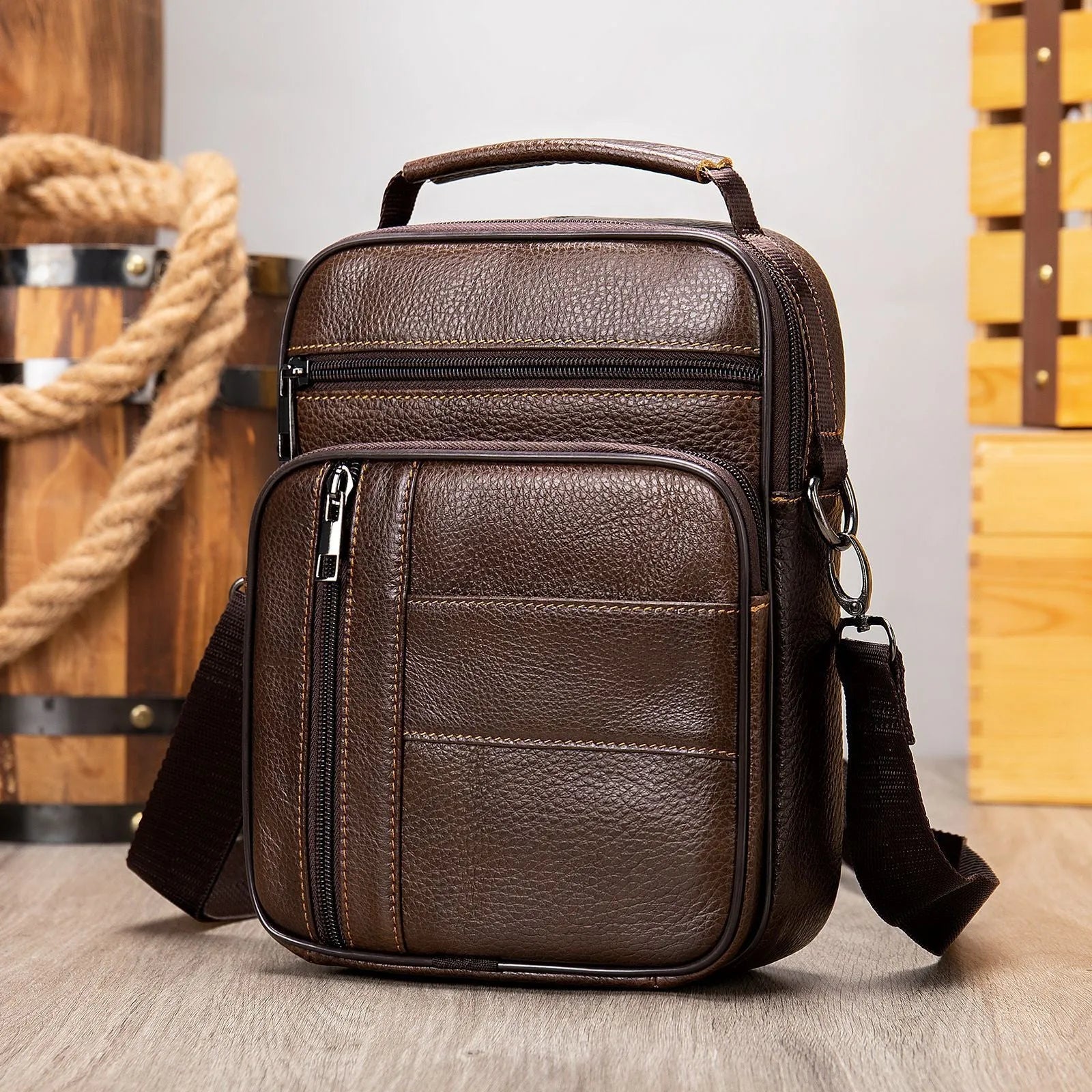 Vertical black genuine cowhide leather shoulder bag with a zip opening and soft handle, shown with internal organiser pockets.