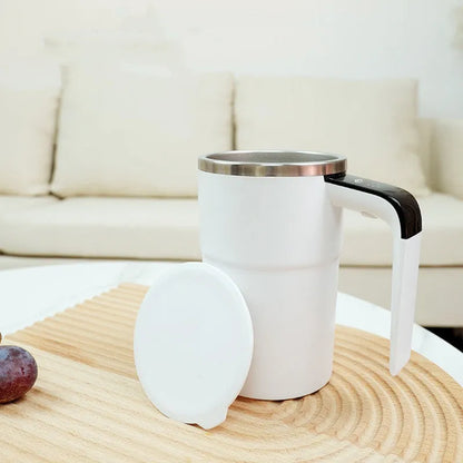 Electric coffee mug with USB charging port, magnetic stirrer, and LCD display showing temperature, in black or white colour.