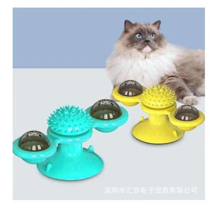 Cat playing with rotating windmill toy featuring luminous balls and suction base