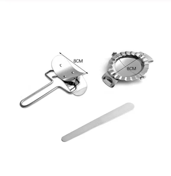 Stainless steel dumpling mould and rectangular dough cutter on a kitchen surface.