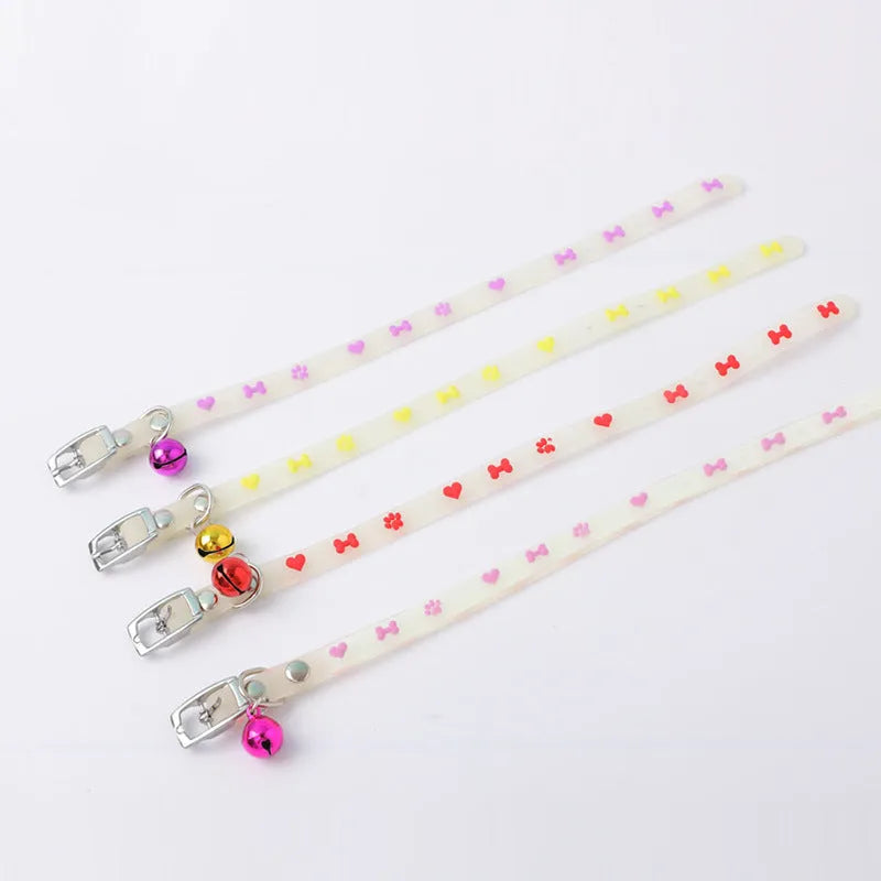 Glowing adjustable luminous collar for cats on a dark background, showing silicone chain and metal bell.