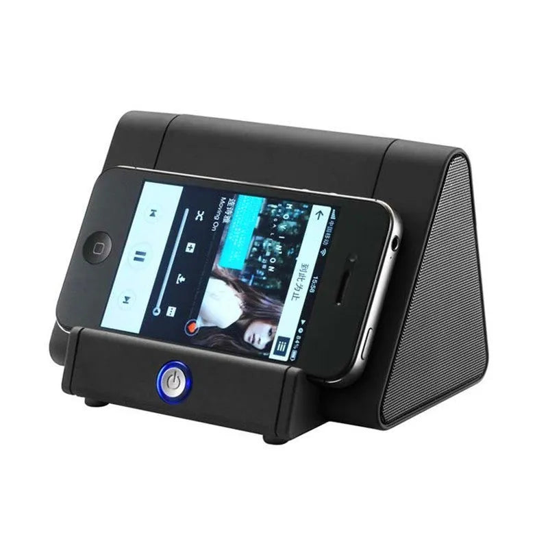 Compact black or white wireless Bluetooth speaker with charging cable.